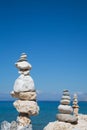 Pyramid of stones at the ocean. Blue water background.