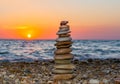 Pyramid of stones on pebble beach at sunset Royalty Free Stock Photo