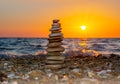 Pyramid of stones on pebble beach at sunset Royalty Free Stock Photo