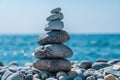 Pyramid stones on the seashore on a sunny day on the blue sea background. Happy holidays. Pebble beach, calm sea, travel Royalty Free Stock Photo