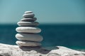 Pyramid stones on the seashore on a sunny day on the blue sea background. Happy holidays. Pebble beach, calm sea, travel Royalty Free Stock Photo