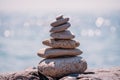 Pyramid stones on the seashore on a sunny day on the blue sea background. Happy holidays. Pebble beach, calm sea, travel Royalty Free Stock Photo