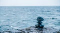 Pyramid stones on the seashore on a sunny day on the blue sea background. Happy holidays. Pebble beach, calm sea, travel Royalty Free Stock Photo