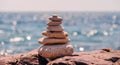 Pyramid stones on the seashore on a sunny day on the blue sea background. Happy holidays. Pebble beach, calm sea, travel Royalty Free Stock Photo