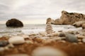 Pyramid stones on the seashore on a sunny day on the blue sea background. Happy holidays. Pebble beach, calm sea, travel Royalty Free Stock Photo