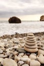 Pyramid stones on the seashore on a sunny day on the blue sea background. Happy holidays. Pebble beach, calm sea, travel Royalty Free Stock Photo