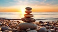 Pyramid stones on the seashore with warm sunset on the sea background. Happy holidays. Pebble beach, calm sea, travel destination