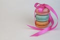 Pyramid of 3 three macaroons macarons tied with a pink ribbon, festive decor sweet dessert, white background Royalty Free Stock Photo