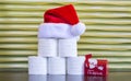 A pyramid of toilet paper with a Santa Claus hat and tiny mailbox  against a gold background Royalty Free Stock Photo