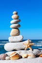 Pyramid of white stones and shells on a background of blue sky and sea