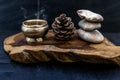 Pyramid of zen stones, Pine cones and Burning candle on old wooden background, Meditation concept, dark toned style Royalty Free Stock Photo