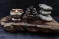 Pyramid of zen stones, Pine cones and Burning candle on old wooden background, Meditation concept, dark toned style Royalty Free Stock Photo