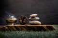 Pyramid of zen stones, Pine cones and Burning candle on old wooden background, Meditation concept, dark toned style Royalty Free Stock Photo