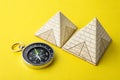 Pyramids and compass on yellow background Royalty Free Stock Photo
