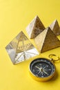 Pyramids and compass on yellow background Royalty Free Stock Photo