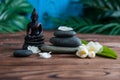 Pyramids of gray zen stones with white flowers, green leaves on wooden background. Concept of harmony, balance and meditation, Royalty Free Stock Photo