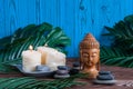 Pyramids of gray zen stones with candles, green leaves on wooden background. Concept of harmony, balance and meditation,