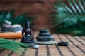 Pyramids of gray zen stones with green leaves and Buddha statue. Concept of harmony, balance and meditation, spa, massage, relax Royalty Free Stock Photo