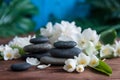 Pyramids of gray zen stones with white flowers, green leaves on wooden background. Concept of harmony, balance and meditation,