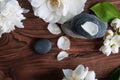 Pyramids of gray zen stones with white flowers, green leaves on wooden background. Concept of harmony, balance and meditation, Royalty Free Stock Photo