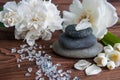 Pyramids of gray zen stones with white flowers, green leaves on wooden background. Concept of harmony, balance and meditation, Royalty Free Stock Photo