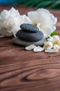 Pyramids of gray zen stones with White flowers, green leaves on wooden background. Concept of harmony, balance and meditation, Royalty Free Stock Photo