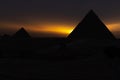 The pyramids at sunset, silhouettes in the dark, Giza, Egypt