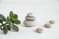 Pyramids of white zen stones with green leaves and Buddha statue. Concept of harmony, balance and meditation, spa, massage, relax Royalty Free Stock Photo