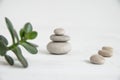 Pyramids of white zen stones with green leaves. Concept of harmony, balance and meditation, spa, massage, relax Royalty Free Stock Photo