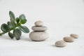 Pyramids of white zen stones with green leaves. Concept of harmony, balance and meditation, spa, massage, relax Royalty Free Stock Photo