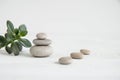 Pyramids of white zen stones with green leaves. Concept of harmony, balance and meditation, spa, massage, relax Royalty Free Stock Photo