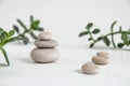 Pyramids of white zen stones with green leaves. Concept of harmony, balance and meditation, spa, massage, relax Royalty Free Stock Photo