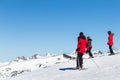 PYRENEES, ANDORRA - FEBRUARY 13, 2019: Three unknown skiers in red jackets on a mountainside.