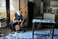 Pyromaniac man in a room with burnt objects, madness concept