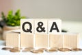 Q AND A concept with wooden blocks and coins on table  business concept. Q AND A - question and answer Royalty Free Stock Photo