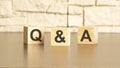 Q and A text from wooden blocks on a gray stone background. QA is short for Question and Answer information concepts Royalty Free Stock Photo