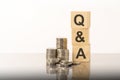 q and a - text on wooden cubes on white background with coins Royalty Free Stock Photo