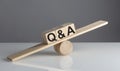 Q and A on wooden cubes on wooden balance , business concept