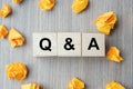 Q&A word with wooden cube block and yellow crumbled paper on table background. FAQ frequency asked questions, Answer, Question Royalty Free Stock Photo