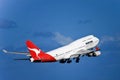Qantas Boeing 747 jet in flight with landing gear.