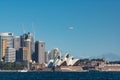 Qantas plane flying above Sydney Opera House and Sydney CBD