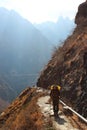 Qiaotou, China - March 11, 2012: A hiker in the central part of one of the deepest ravines of the world, Tiger Leaping Gorge in