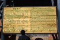 Qiaotou, China - March 11, 2012: A tourist reads the information sign in one of the deepest ravines of the world, Tiger Leaping