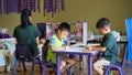 Qingyuan, China - June 23, 2016: Two little boys in the classroom sitting under the table during the class