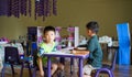 Qingyuan, China - June 23, 2016: Two little boys in the classroom sitting under the table during the class Royalty Free Stock Photo