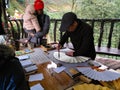 People writing Chinese on a paper foldable fan