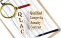 QLAC Qualified Longevity Annuity Contract text on wooden block on chart background Royalty Free Stock Photo