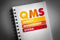 QMS - Quality Management System acronym on notepad, business concept background Royalty Free Stock Photo