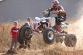 Quad Bike airborne over hump in trail of dust on sand track duri Royalty Free Stock Photo