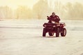 Quad bike driver riding over a frozen lake